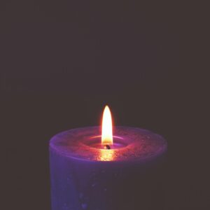 A soothing candle flame glowing in darkness, creating a peaceful mood.